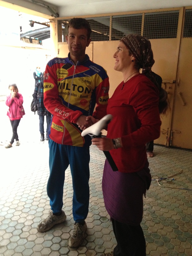 AWT team mechanic shaking hands with Ky Hunter, the women sent by Liv/giant to assemble the bikes they donated and to help out as a bike mechanic. Photo by Shannon Galpin.